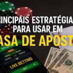 Celular com apostas esportivas, fichas de pôquer, cartas e dinheiro sobre a mesa